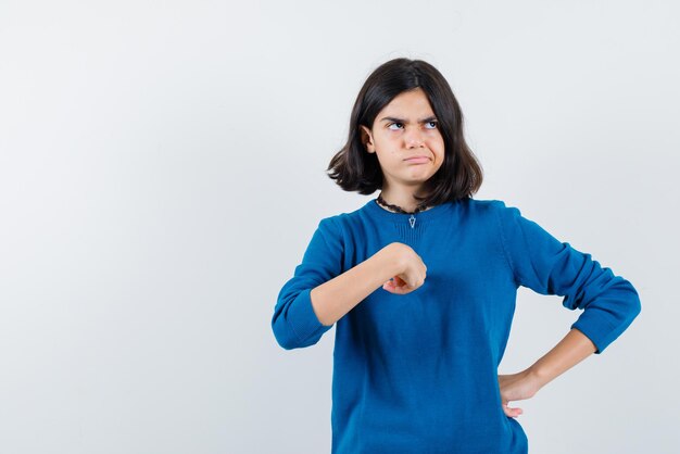 Unsatisfied teenage girl raising her fists on white background