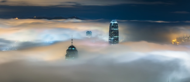 Upper parts of skyscrapers covered in mist at night