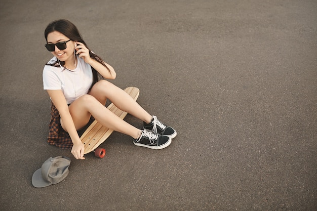 Free photo upper view carefree hipster girl in sunglasses, snapback on the ground