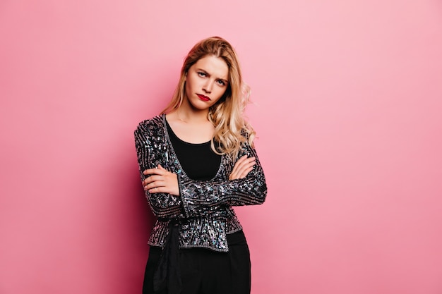 Upset caucasian girl with red lips. Wonderful european woman in sparkle jacket posing with arms crossed.