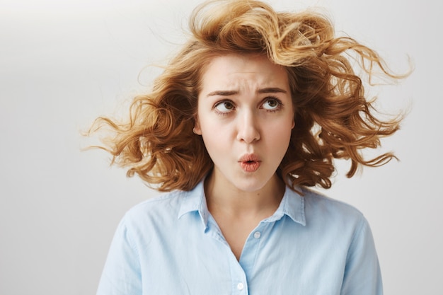 Free photo upset cute girl complaining wind ruined haircut