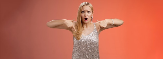 Free Photo upset disappointed fooled blond elegant girlfriend in silver dress frowning grimacing bothered point