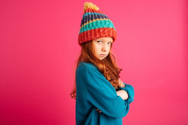 Upset ginger girl looking camera and and holding hands folded isolated