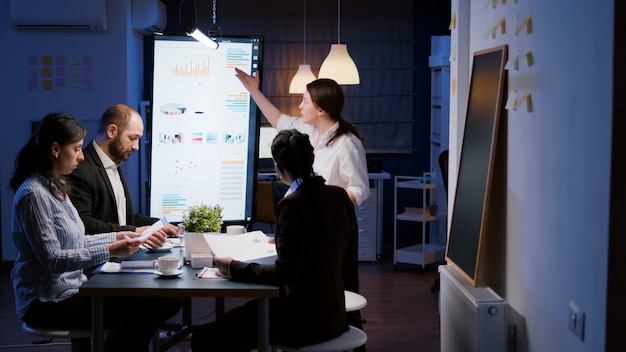 Free photo upset irritated frustrated businesswoman entering in office meeting room late at night screaming at teamwork throwing strategy paperwork