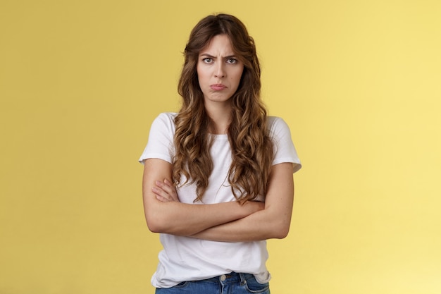 Free photo upset jealous moody clingy girlfriend sulking offended cross hands chest blocking pose frowning disappointed complaining unfair treatment stand yellow background bothered pouting childish