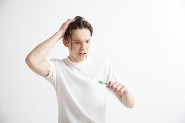 Upset man looking in pregnancy test. Frustrated model