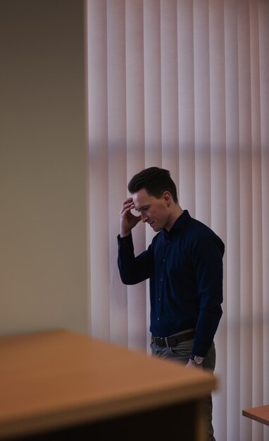 Upset man standing with hand on forehead