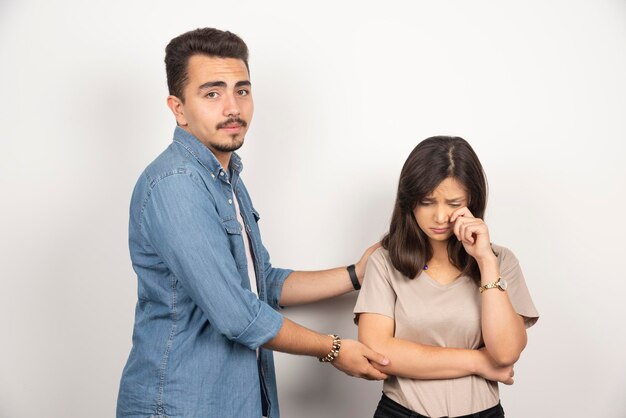 Upset man and weeping woman on white.