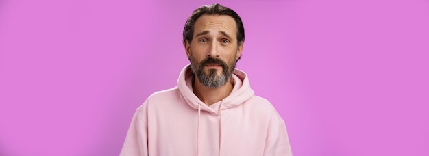 Free Photo upset worried unconfident adult bearded caucasian man grey hair frowning look hopefully nervously waiting important news standing anxious hesitant unhappy standing purple background unwell