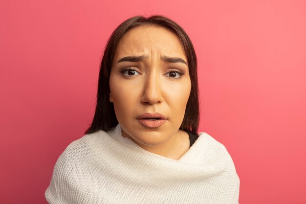 Upset young woman with white scarf being confused 