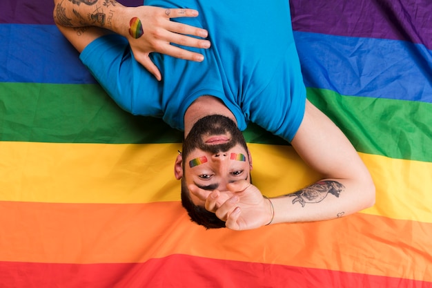 Free photo upside down man with lgbt colored symbol and tattoo