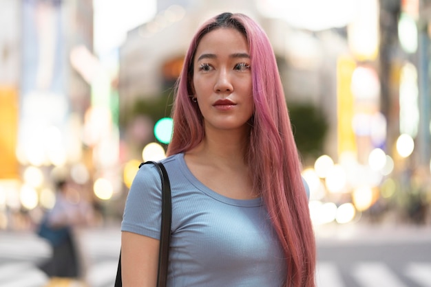 Urban portrait of young woman with pink hair