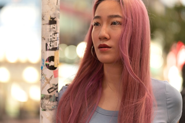 Free photo urban portrait of young woman with pink hair