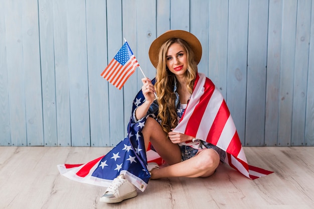 Free Photo usa independence day concept with sitting woman holding flag