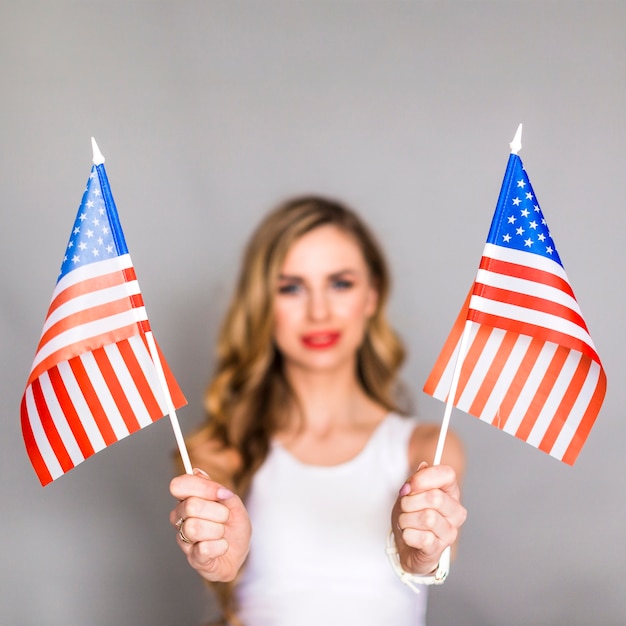 Usa independence day concept with woman holding two flags