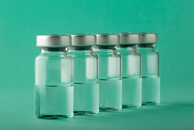 Free Photo vaccine bottle arrangement on green