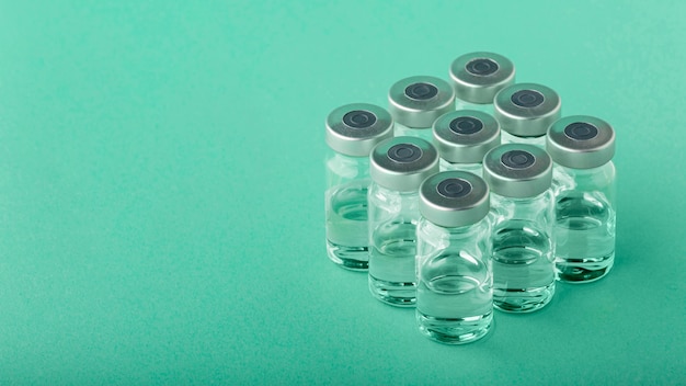 Free photo vaccine bottle arrangement on green