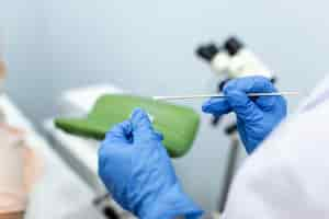 Free photo vaginal smear closeup of doctor hand holds gynecological examination instruments gynecologist working in the obstetrics and gynecology clinic