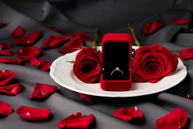 Free photo valentine's day table set with roses and engagement ring on plate