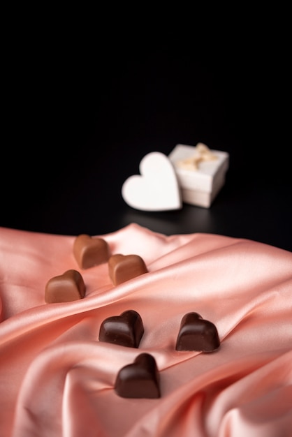 Free photo valentines day chocolates on satin with copy space