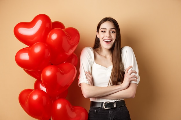 Valentines day concept beautiful young woman having fun laughing and smiling at camera standing near...