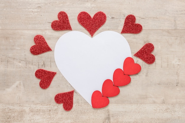 Valentines day hearts with paper on wooden background