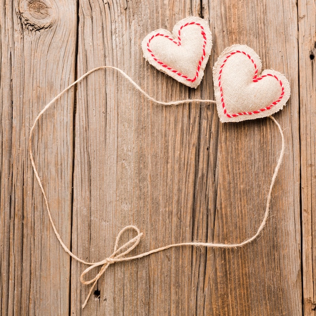 Valentines day ornaments with string on wooden background