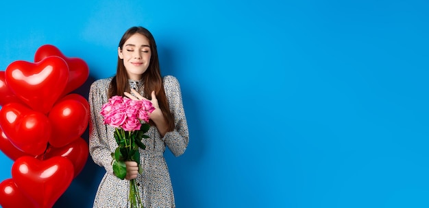 Free photo valentines day romantic lovely woman in dress close eyes and smiling receiving flowers from lover sm