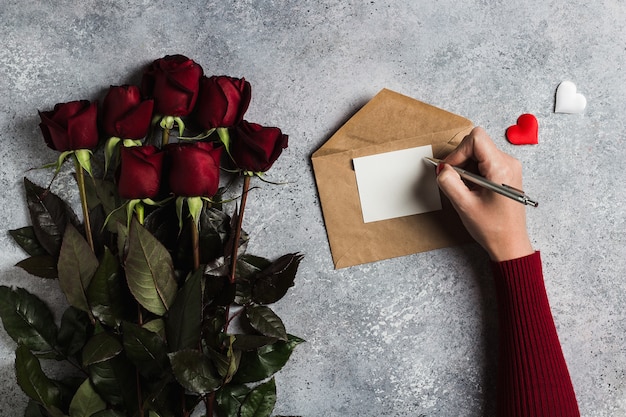 Valentines day woman hand holding pen writing love letter with greeting card