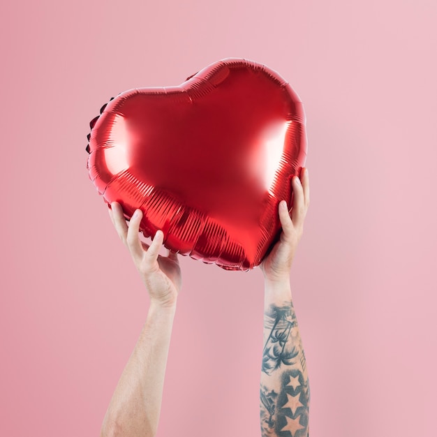 Free photo valentines heart balloon held by a person