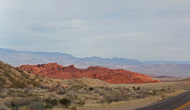 Valley of Fire Nevada from the entrance car parking lot.Bright red Aztec sandstone outcrops nestled in gray and tan limestone