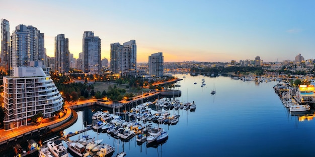 Vancouver harbor view with urban apartment buildings and bay boat in Canada.