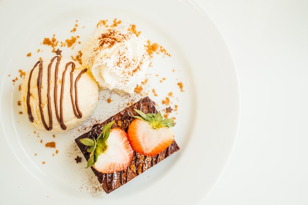 Vanilla ice cream with chocolate brownie cake with strawberry on top