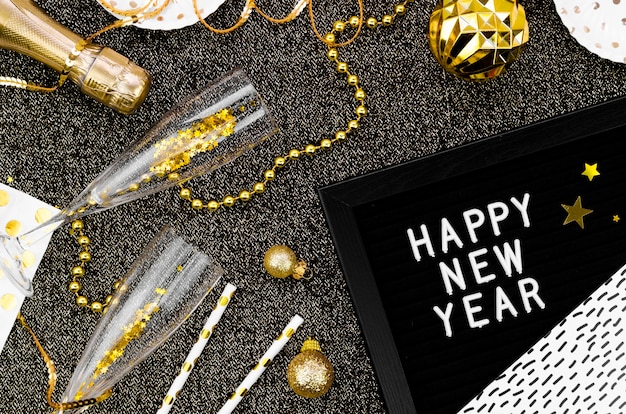 Free Photo variety of accessories and glasses on black background and happy new year garland