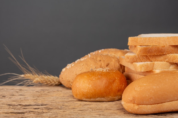 Variety of bread on wooden table on an old wooden background.