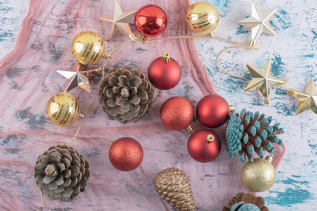 Variety of Christmas tree ornaments on a piece of burlap on the blue textured