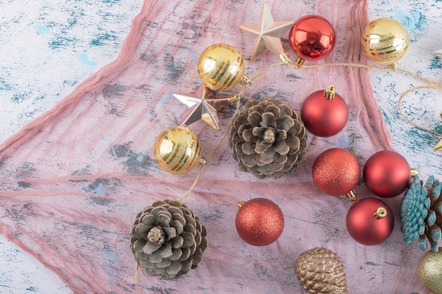 Variety of Christmas tree ornaments on a piece of burlap on the blue textured