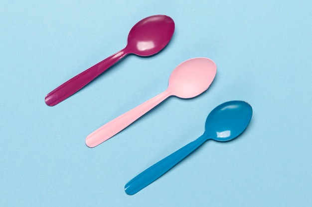 Free photo variety of coloured spoons on blue background