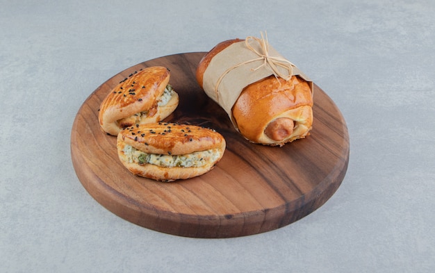 Variety of delicious pastries on wooden board.