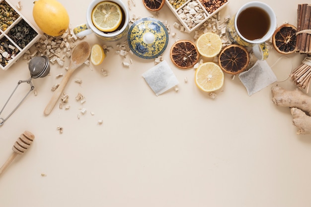 Variety of herbs; spoon; honey dipper; tea strainer; dried grape fruit and ingredients