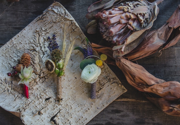 Variety of jacket pins prepared with dry fruits and seasonal symbolic flowers on the table.