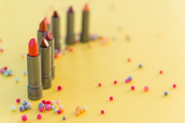 Free photo variety of lipsticks shades arranged in row on yellow background