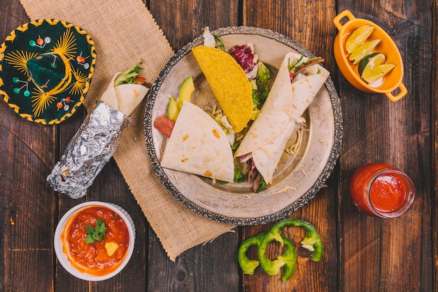 Variety of mexican food with hat on wooden table