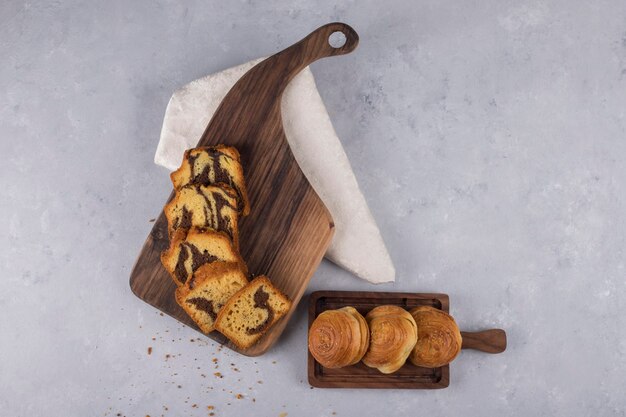 Variety of pastries and buns on a wooden board