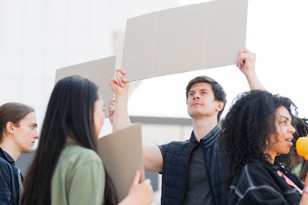 Free photo variety of people protesting in the streets holding cardboards