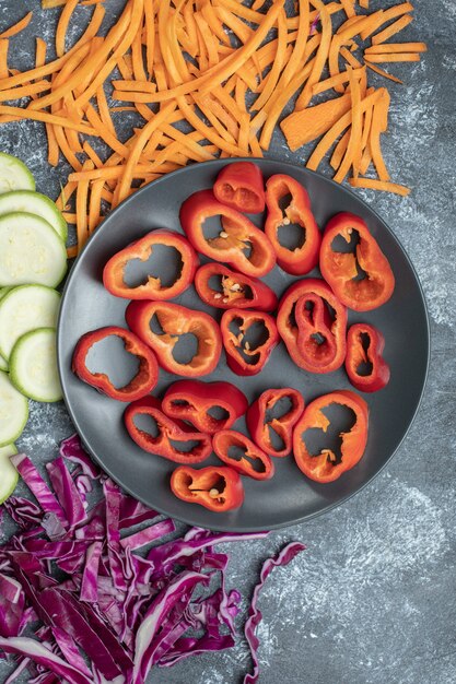 Variety of sliced vegetables on marble surface