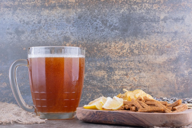 Variety of snacks and glass of beer on marble table. High quality photo