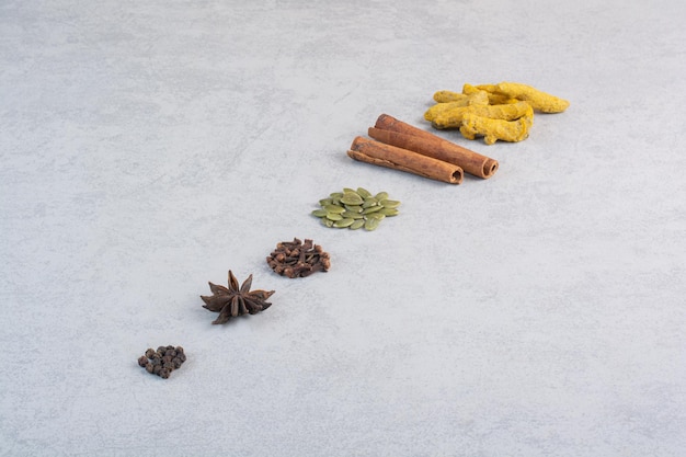 Free photo variety of spices and herbs isolated on concrete background.