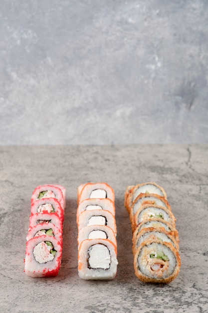 Free Photo variety of tasty sushi rolls placed on marble background