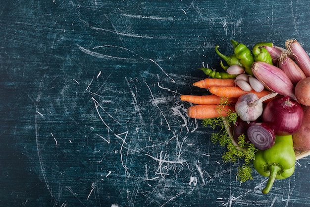 Variety of vegetables isolated on blue table on the right side.